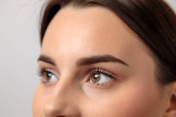 Woman showing perfect eyebrows after microblading treatment