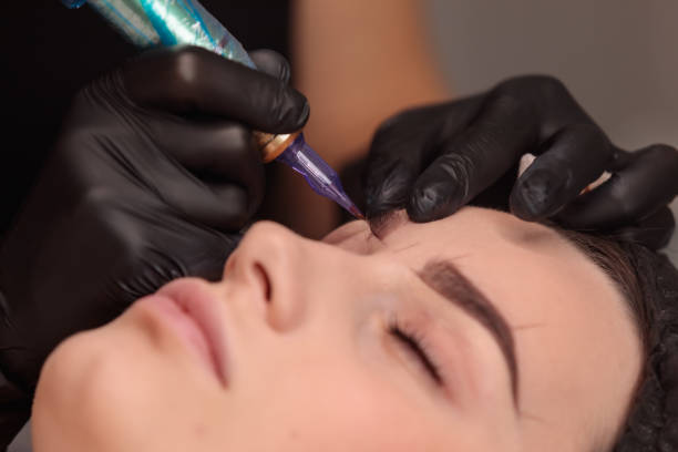 istock Beautician applying permanent makeup on eyebrows of client 2182775934