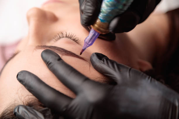 istock Beautician applying permanent eyebrow makeup on woman's face 2182775947