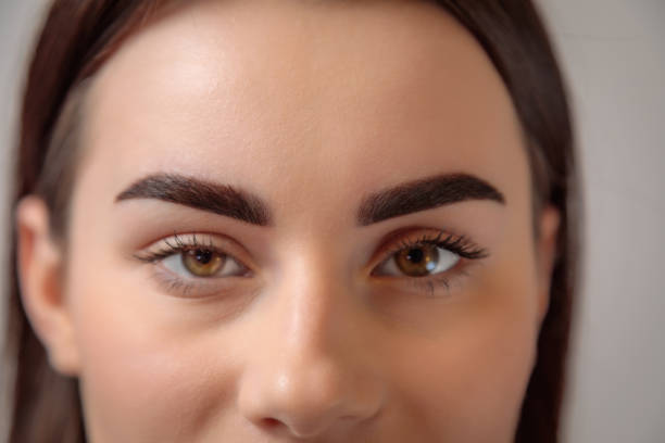 istock Beautician showing perfect eyebrows after permanent makeup treatment 2182775970