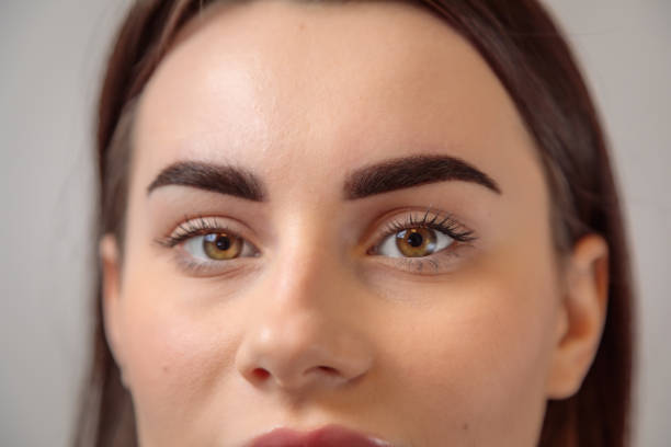 istock Beautician showing perfect eyebrows after microblading treatment 2182775973