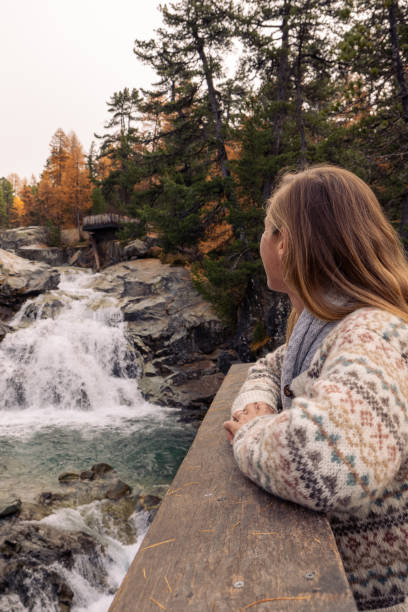 istock Woman Admiring Autumn Waterfall in Forest 2182780173