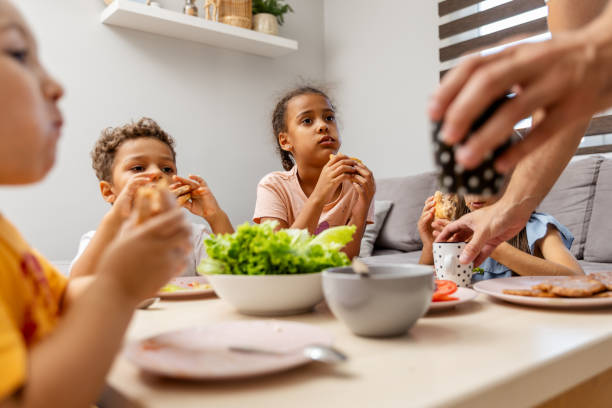 istock Children enjoying lunch together at a cozy home setting 2182784359