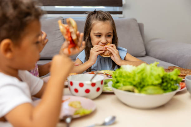 istock Children enjoying a meal together at a cozy table 2182784492