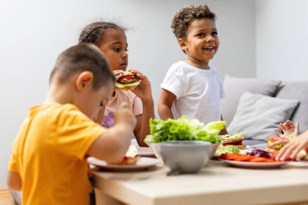 istock Children Eating Together at a Table with Sandwiches 2182785630