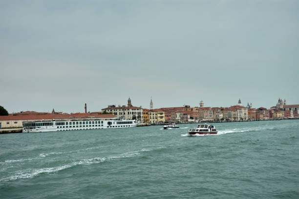 Venice,Italy;October,17,2024:the melancholic beauty of a Venetian canal on a cloudy day. Soft shadows from the overcast sky gently fall on the calm waters and historic buildings lining the canal, creating a serene and tranquil atmosphere