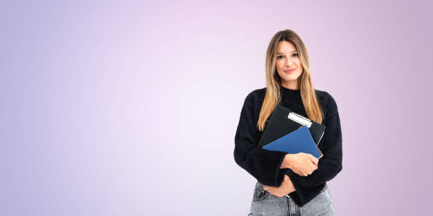 istock A woman with long hair holding folders and documents, standing a 2182789651