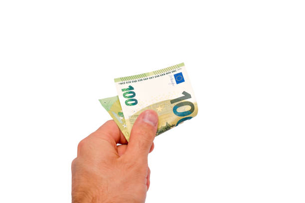 A hand holding a hundred euro bill on white background. The person holding the bill is likely to be a business owner or a wealthy individual.