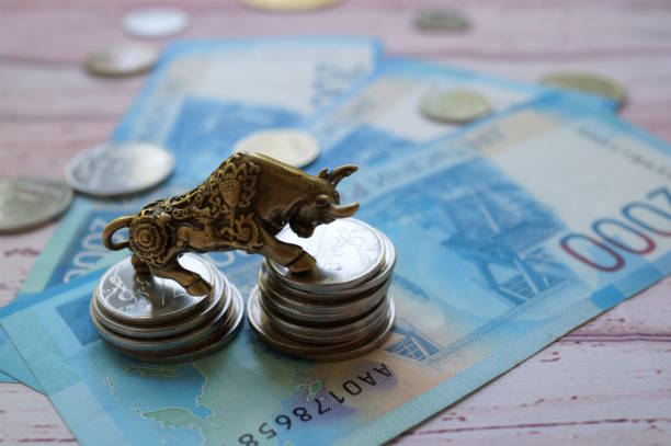 istock A bull statuette with coins and banknotes. Financial success. 2182796550