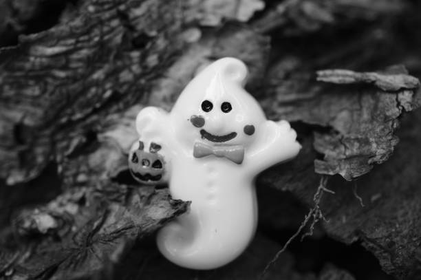 A toy ghost on a wooden background.