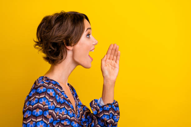 istock Side profile photo of young charming lady loud screaming touch cheek looking empty space telling truth isolated on yellow color background 2182797871