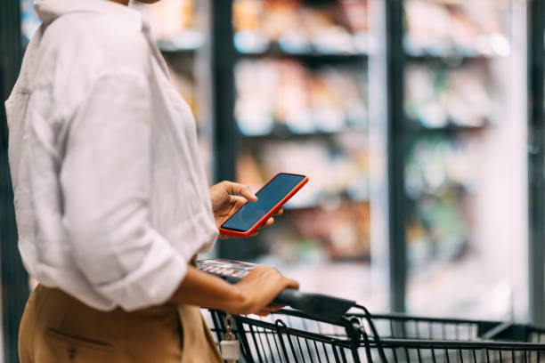 istock Woman Using Smartphone While Shopping In Grocery Store Aisle 2182798037