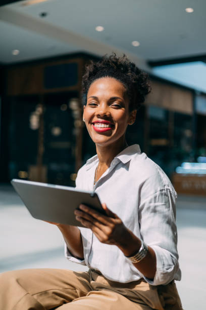 istock Confident Woman Smiling While Holding a Digital Tablet Outdoors 2182798055