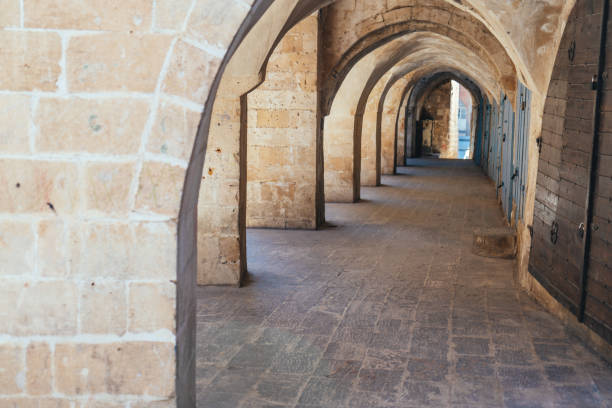 Dubrovnik, Croatia - January 13, 2019: This arched stone corridor reflects Dubrovnik’s medieval charm, featuring robust masonry and elegant architectural symmetry. The dim lighting and textured walls create a timeless atmosphere, inviting visitors to explore the historical depth and craftsmanship of the city’s enduring structures.