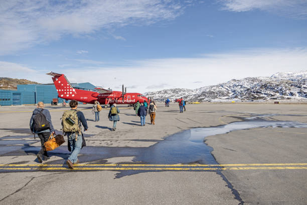 Ilulissat, Jakobshavn, Greenland, Denmark - August 31st 2024: Passengers walking to a Dash 8 airplane from Air Greenland in the airport. Airplanes is the major connection between the cities in the large arctic country.
