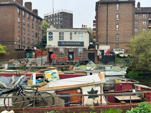 The Anchor & Hope pub in Clapton, London, on the banks of the River Lea, with boats in the foreground and a housing estate in the back ground. November 2024