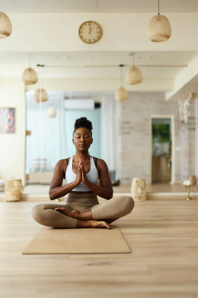 istock Young black woman meditating in prayer pose at Yoga studio. 2182805502