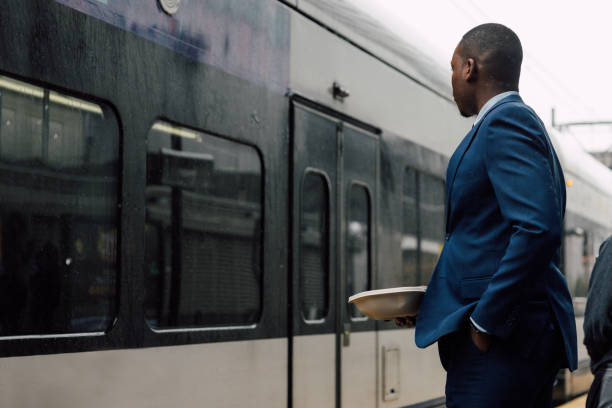 istock Businessman commuting to work, waiting for the train holding his lunch box 2182807183