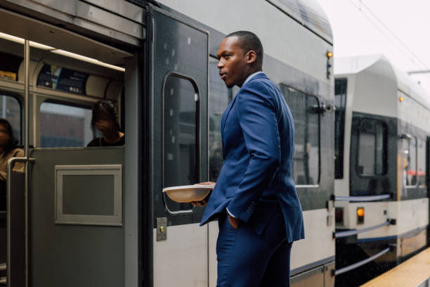 istock Businessman commuting to work, waiting for the train holding his lunch box 2182807310