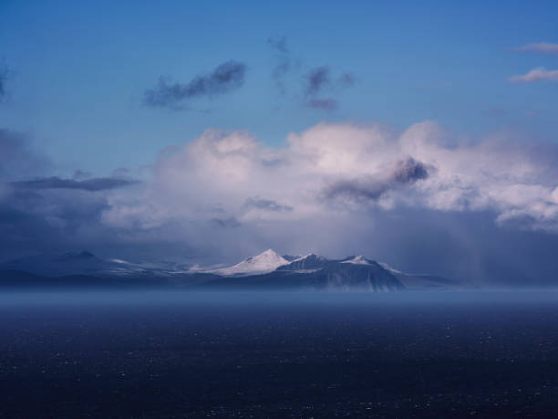 View of the snowcapped mountain range with Atlantic ocean at Faroe Islands. Photographed in medium format.