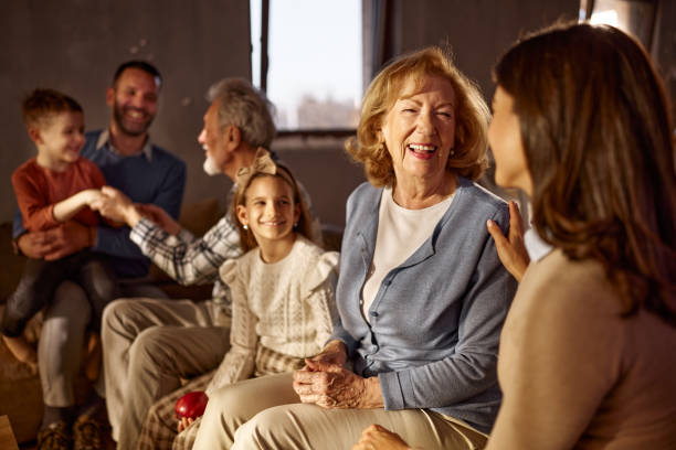 Close-up of young and elderly hands meeting in a gentle touch. Represents empathy, compassion, generational unity, and human connection with black background