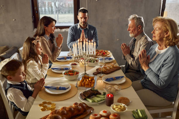 istock Extended family praying before lunch on Hanukkah. 2182810095