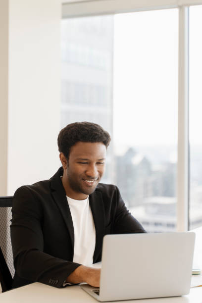 istock Smiling businessman working on laptop in modern office 2182810962