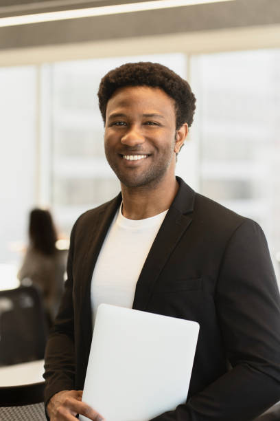 istock Smiling black businessman holding laptop in modern office 2182810991