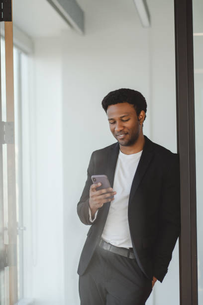 istock Smiling businessman using smartphone in modern office, communicating with clients and colleagues 2182811020