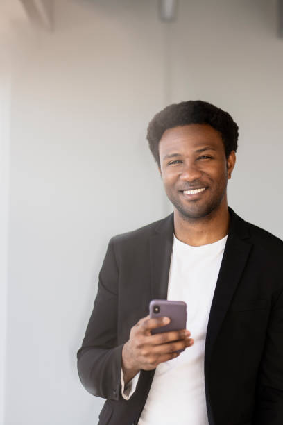 istock Smiling businessman using smartphone in modern office, 2182811026