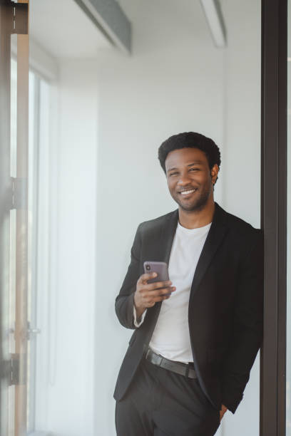 istock Smiling businessman using smartphone in modern office 2182811031