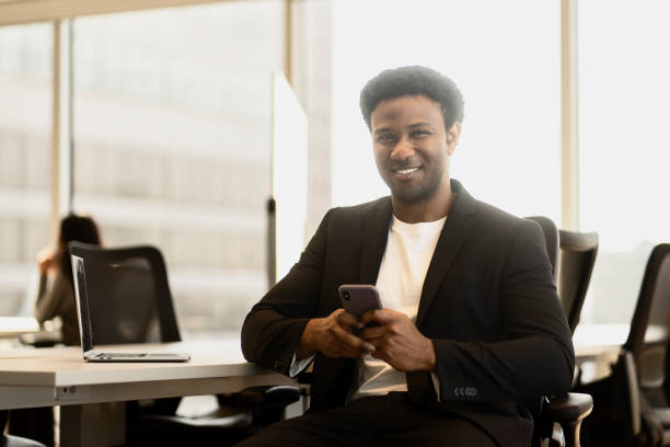 istock Smiling businessman using smartphone in modern office 2182811046