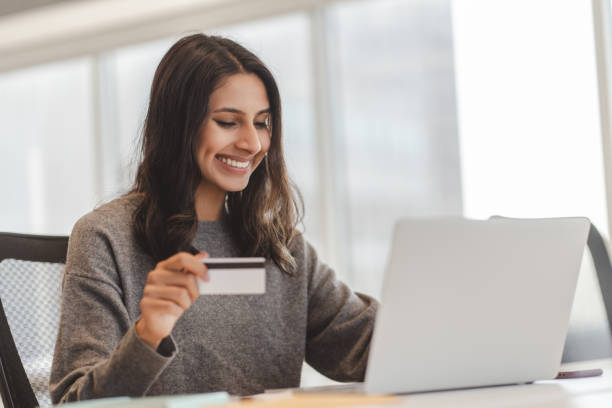 istock Young office worker making online payment using credit card and laptop 2182811088