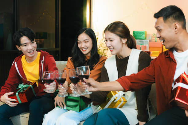 istock drinks and conversation, social gathering and get together at New Year young people, group and gift exchange at the event, celebration at home. 2182811751