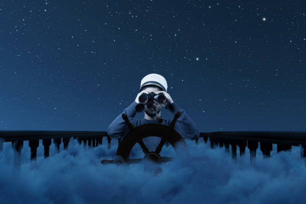 istock Digital composition of a helmsman with binoculars and cap over night clouds viewing to the starry sky 2182812632