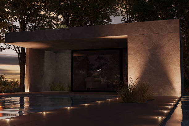 Beautiful detached house with concrete plaster facade behind illuminated footbride and modern pond. 3D Rendering