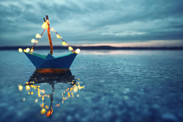 istock magical blue paper boat with lantern at the beach - romantic evening 2182816153