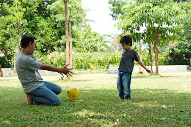 istock A father and son playing soccer in a sunny backyard. 2182817955
