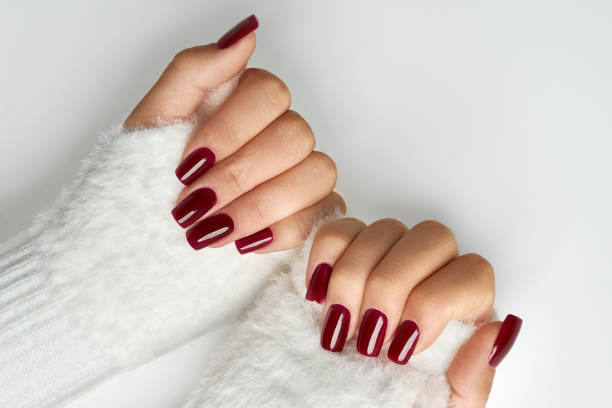 istock Close up woman`s hands with burgundy manicure on white background 2182817996