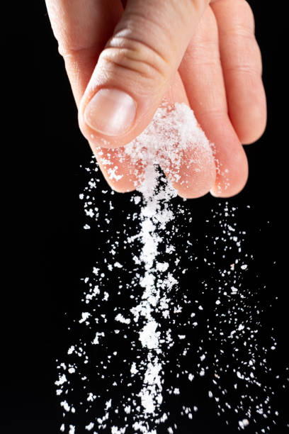 istock Hand pouring white stone salt finely ground, black background. 2182819763