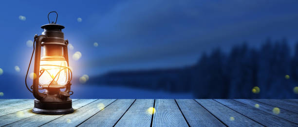 Old glowing lantern on a wooden walkway