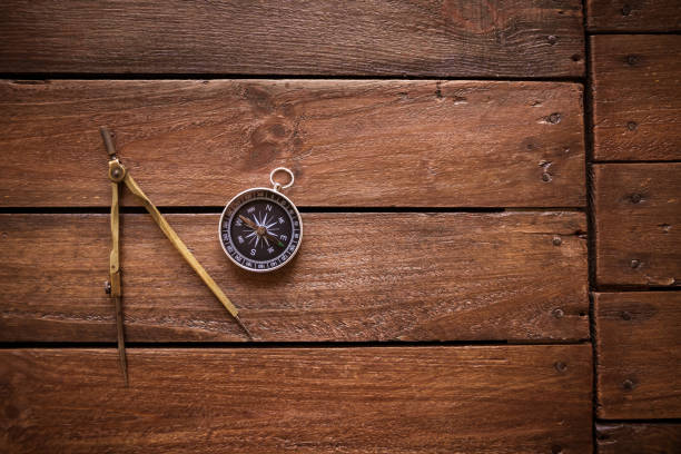 close up of compass against orange background with light effect