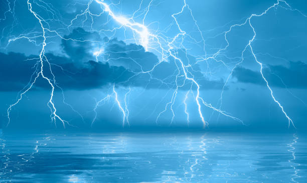 istock Lightning strikes between stormy clouds with blue sea 2182821878