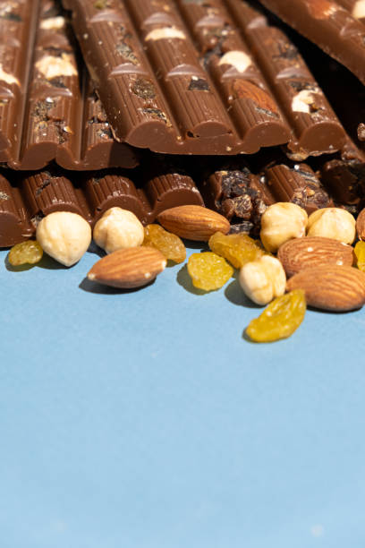 istock Lots of chocolate bars with nuts and raisins on a blue background space for text 2182823400