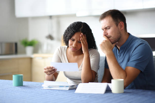 Sad couple or roommates checking bank statement stock photo