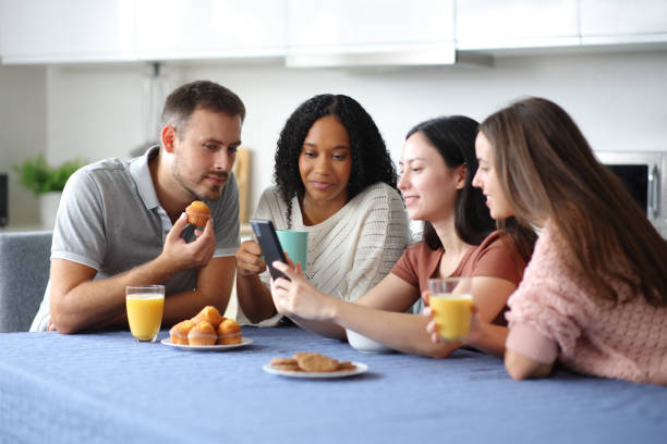 istock Interracial friends checking cell phone at breakfast 2182823972