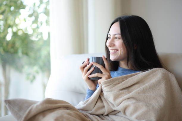 istock Happy asian woman drinking covered with blanket in winter 2182824152