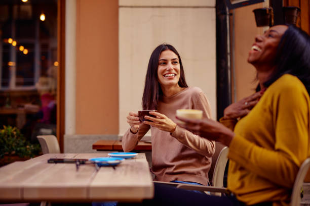 istock Two Friends Laughing Together Over Coffee at a Cozy Cafe 2182824319