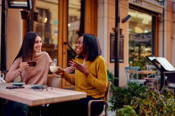 istock Two Friends Laughing Together Over Coffee at a Cozy Cafe 2182824331