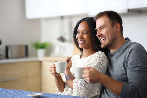 istock Happy interracial couple drinking in the kitchen 2182824393